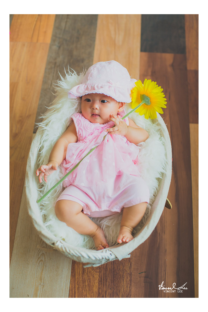 tiny hand holding on with her 1st encounter of a flower